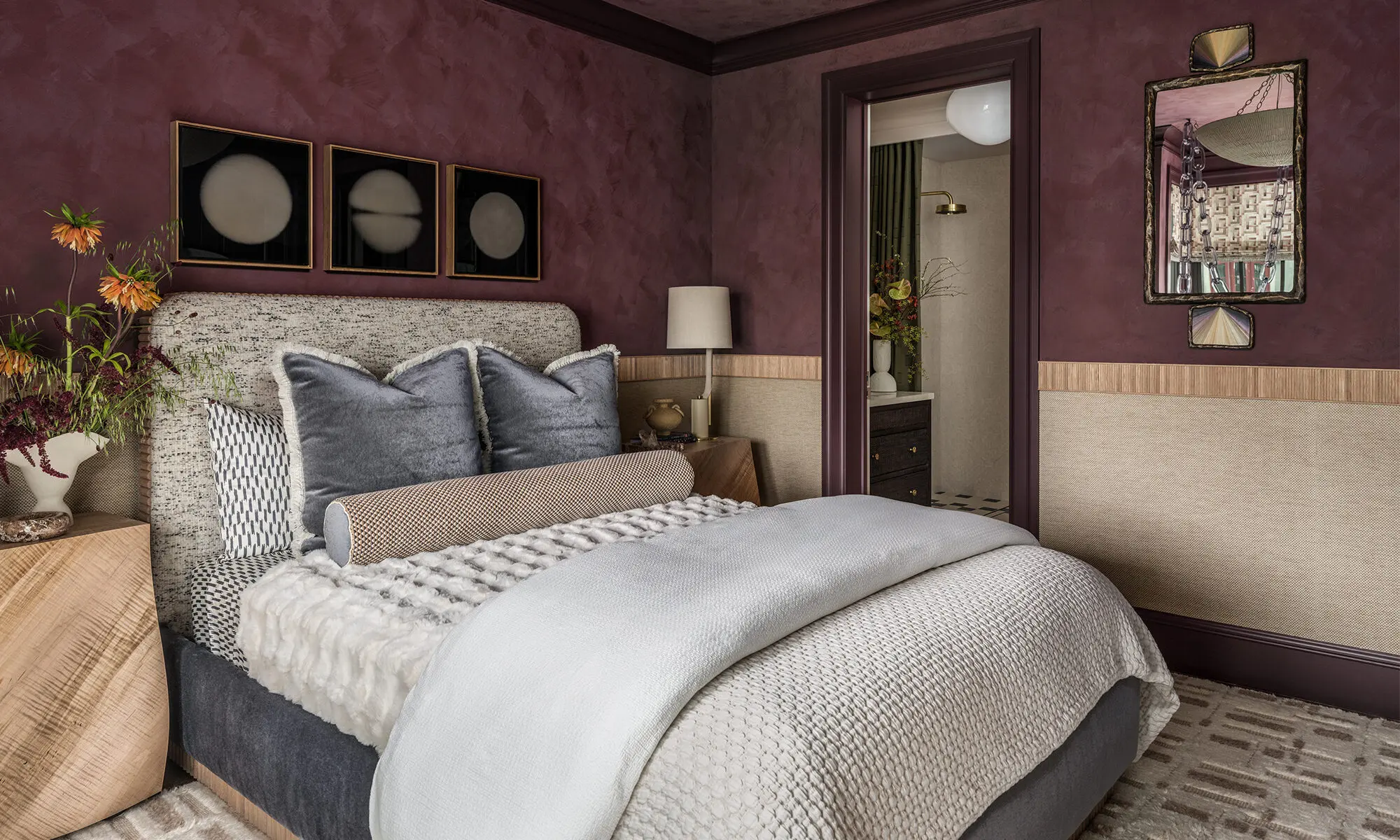 Side of bed view in The Global Nest bedroom showing tactile furnishings, facing ensuite doorway