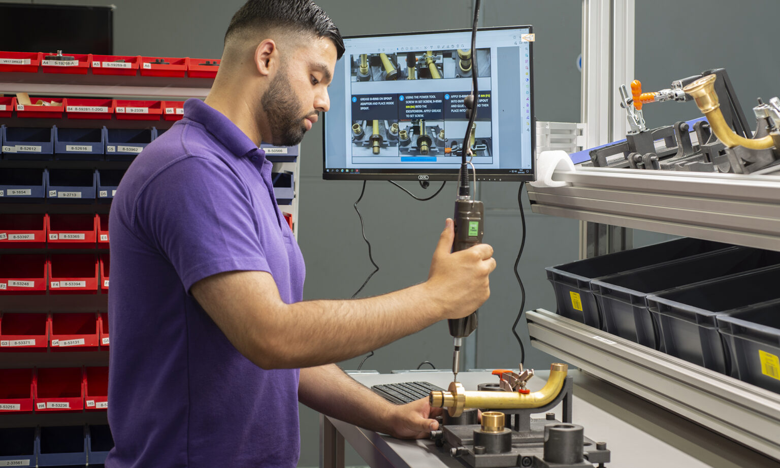 A production engineer photo-documenting the assembling of a ‘dummy model’ in order to find the route of creating manufacturing instructions.