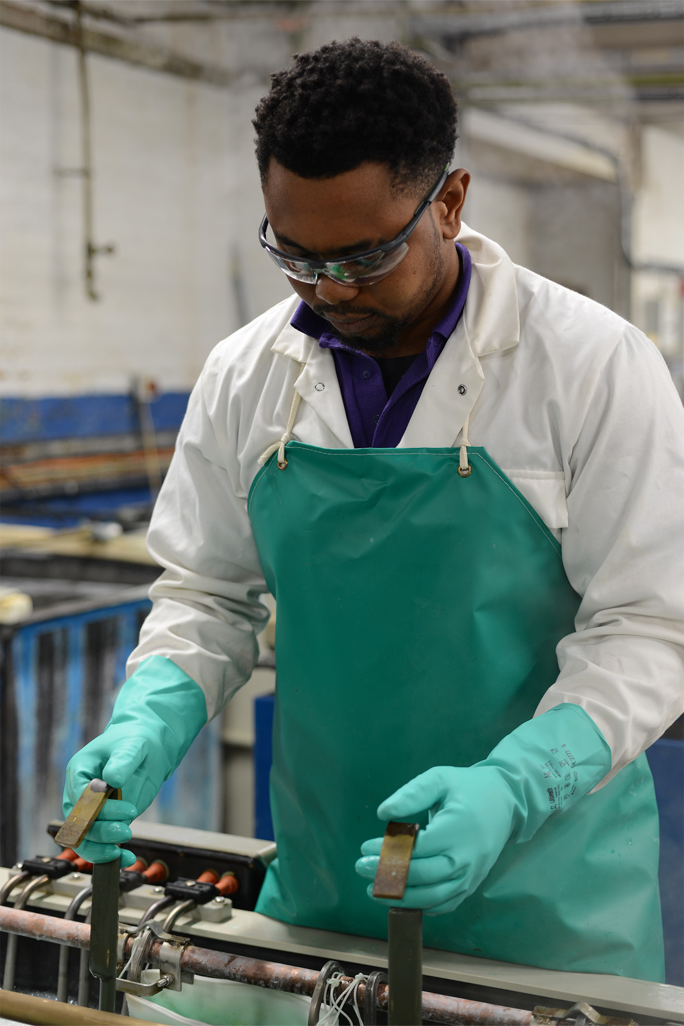 Up close of a person dipping brassware in cleaning solutions by hand
