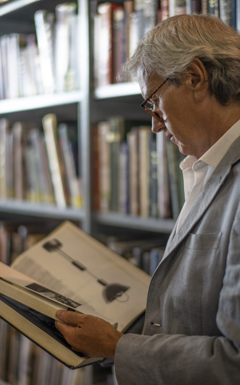 A Samuel Heath product designer gathers design inspiration from a Bauhaus book in a library.