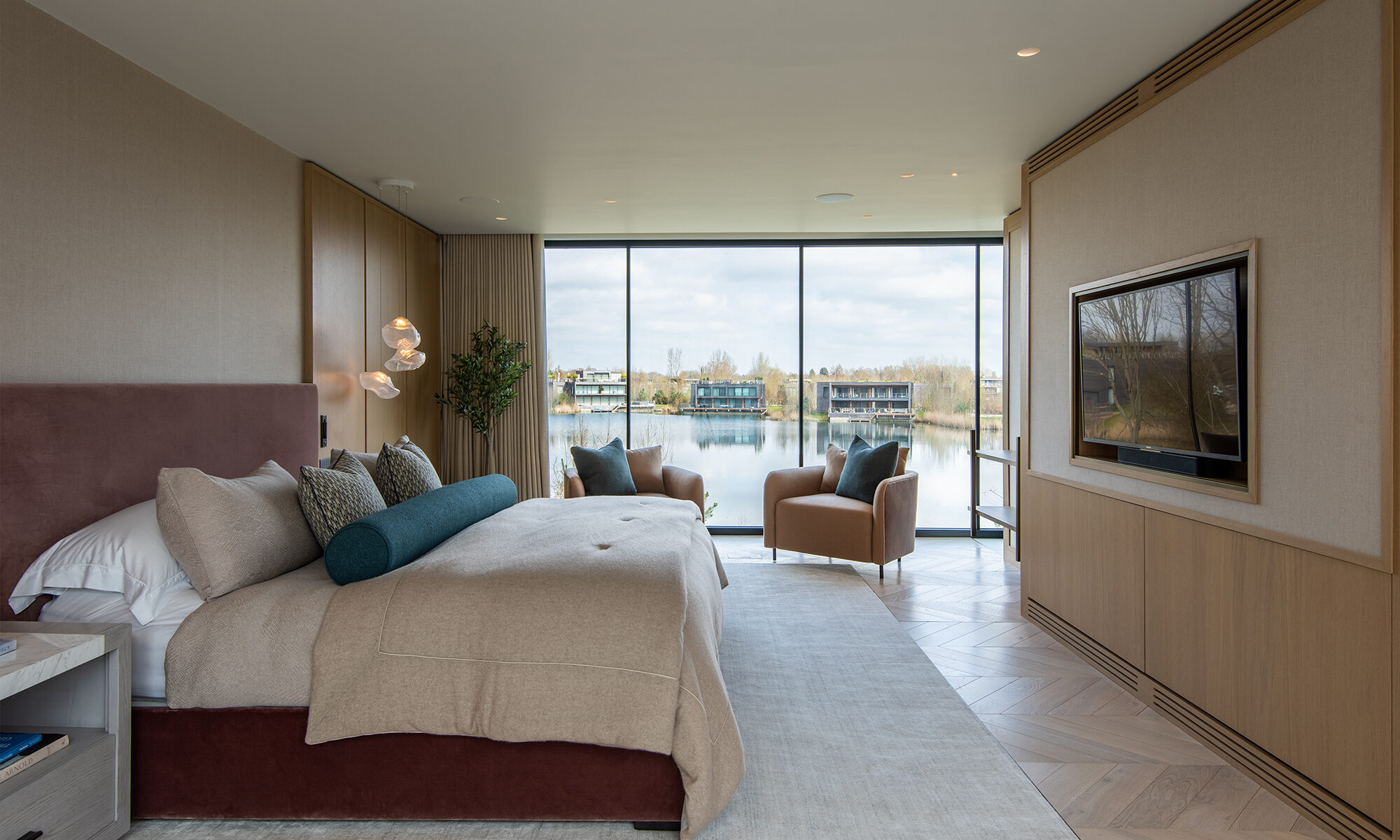 Bedroom with large bed and neutral coloured furnishings