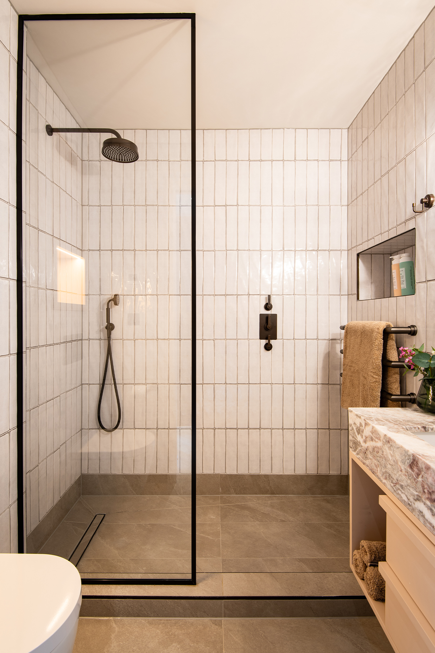 Guest ensuite with cream tiles and concealed shower set by Samuel Heath